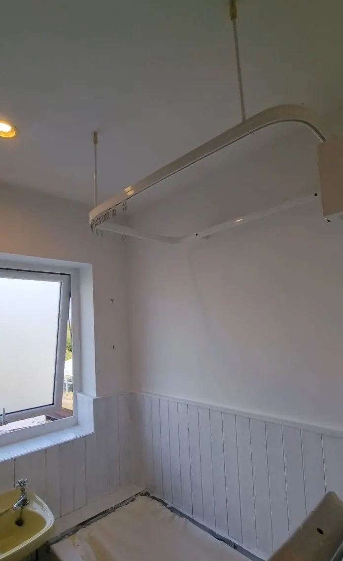 Bathroom with white tongue-and-groove panelling below a window