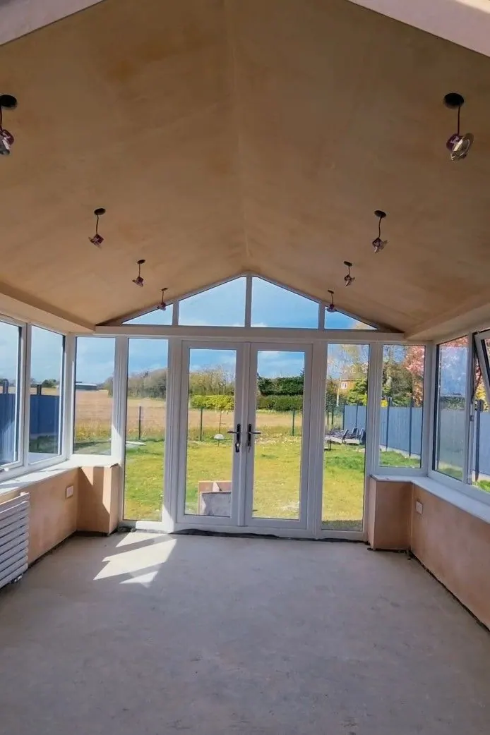 Finished room with a smooth vaulted ceiling and French doors to the garden