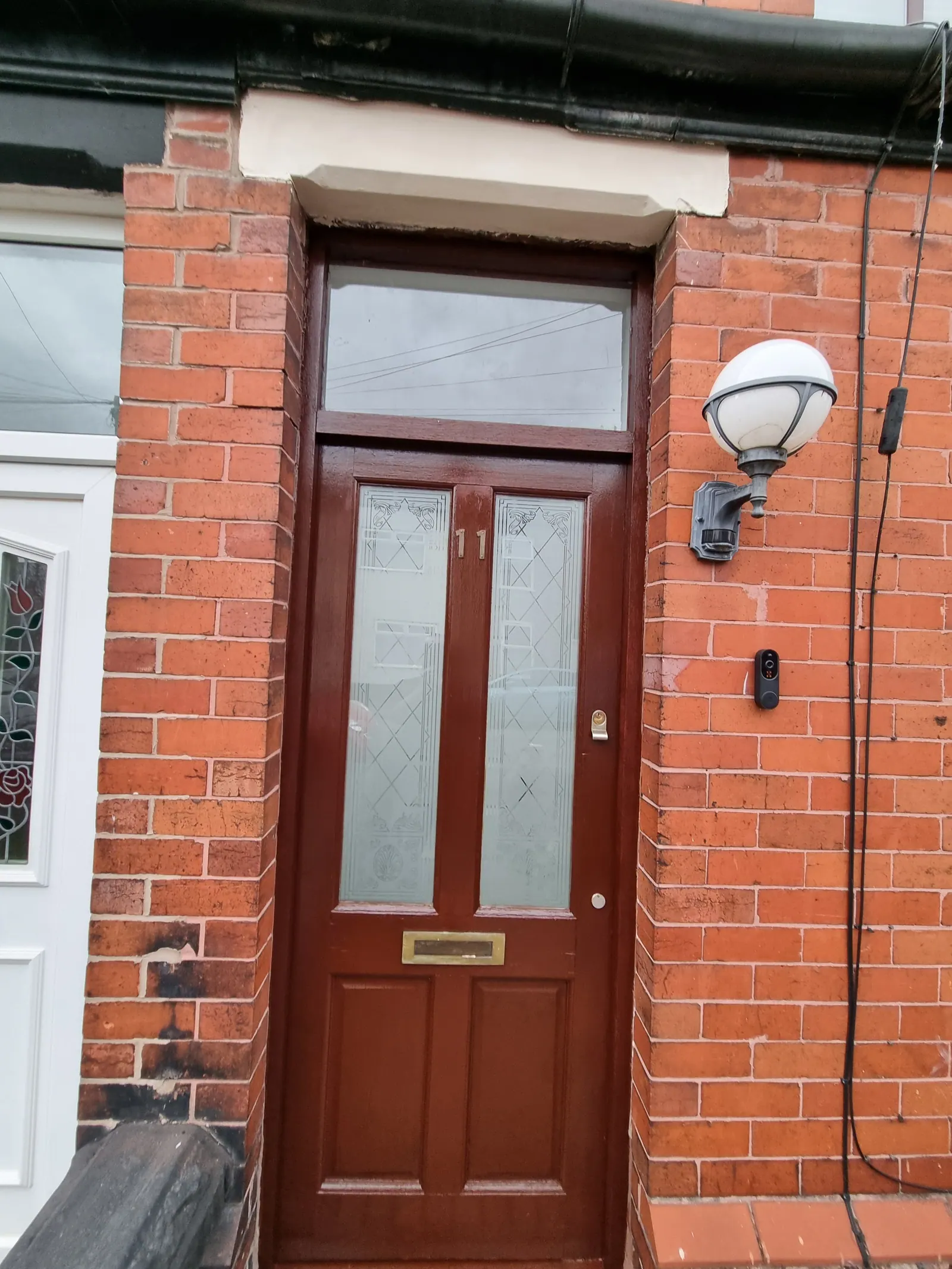 Wooden front door with glazed panels in a red-brick terraced house