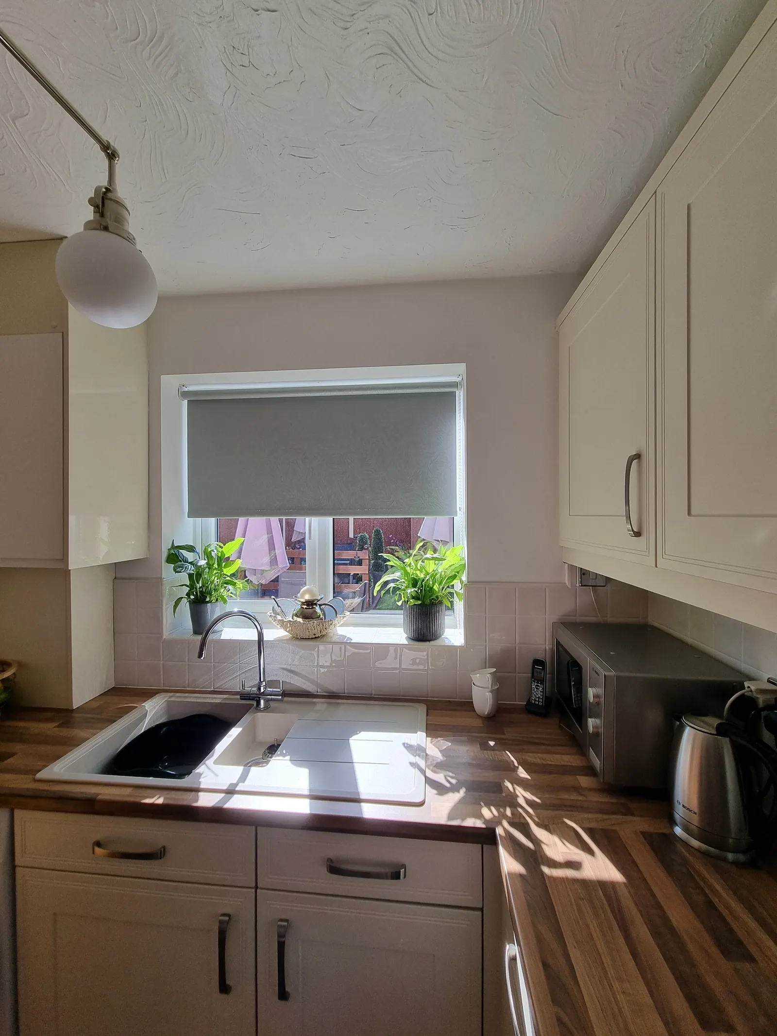 Kitchen sink area with fresh white walls and a tiled splashback