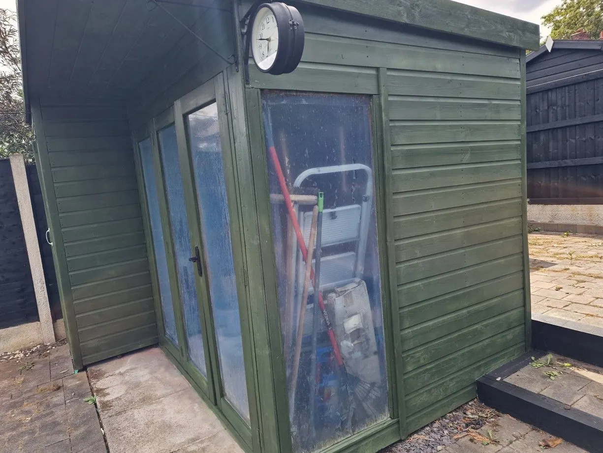 Green painted timber garden room with glazed doors