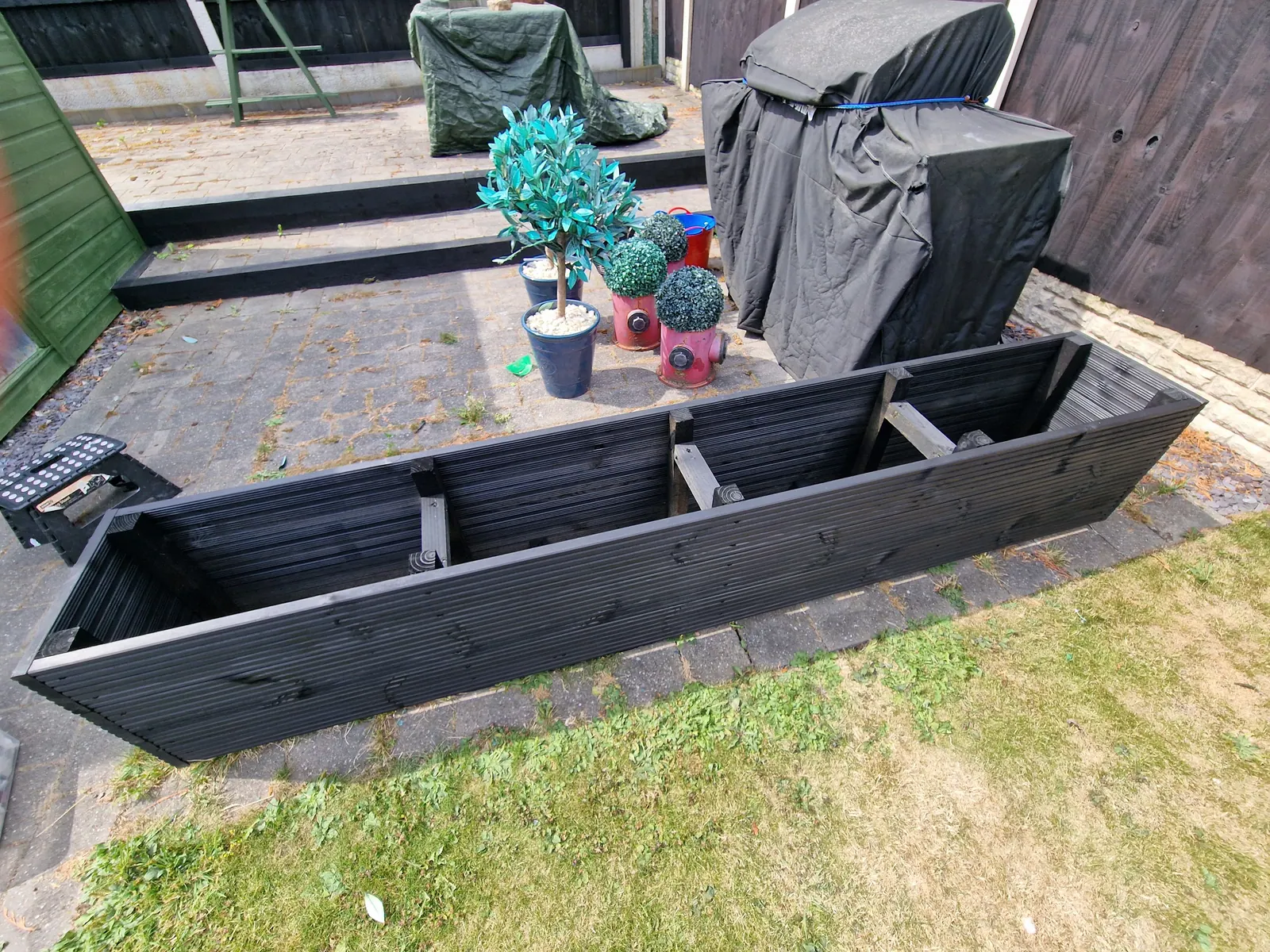 Black painted timber raised planters on a lawn