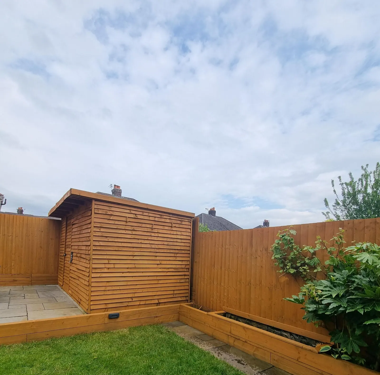 New timber fence panels, a slatted timber garden store and a raised border
