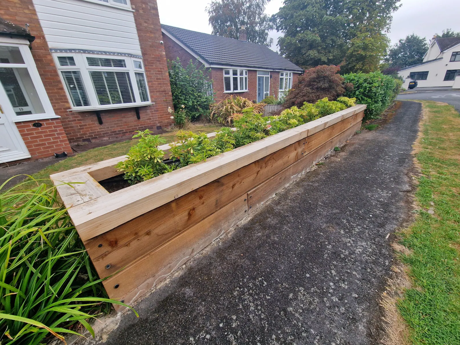 Long timber raised bed along a front garden path